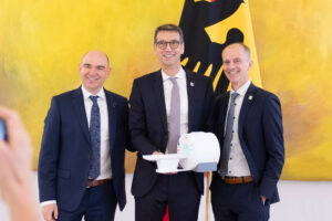 Ein Foto der drei Zukunftspreis-Gewinner 2023 Prof. Dr. Michael Uder Uniklinikum Erlangen, Dr. David Grodzki und Dr. Stephan Biber beide Siemens Healthineers mit dem Modell des Niederfeld-MRTs, das bald in Peru den Betrieb aufnehmen wird.